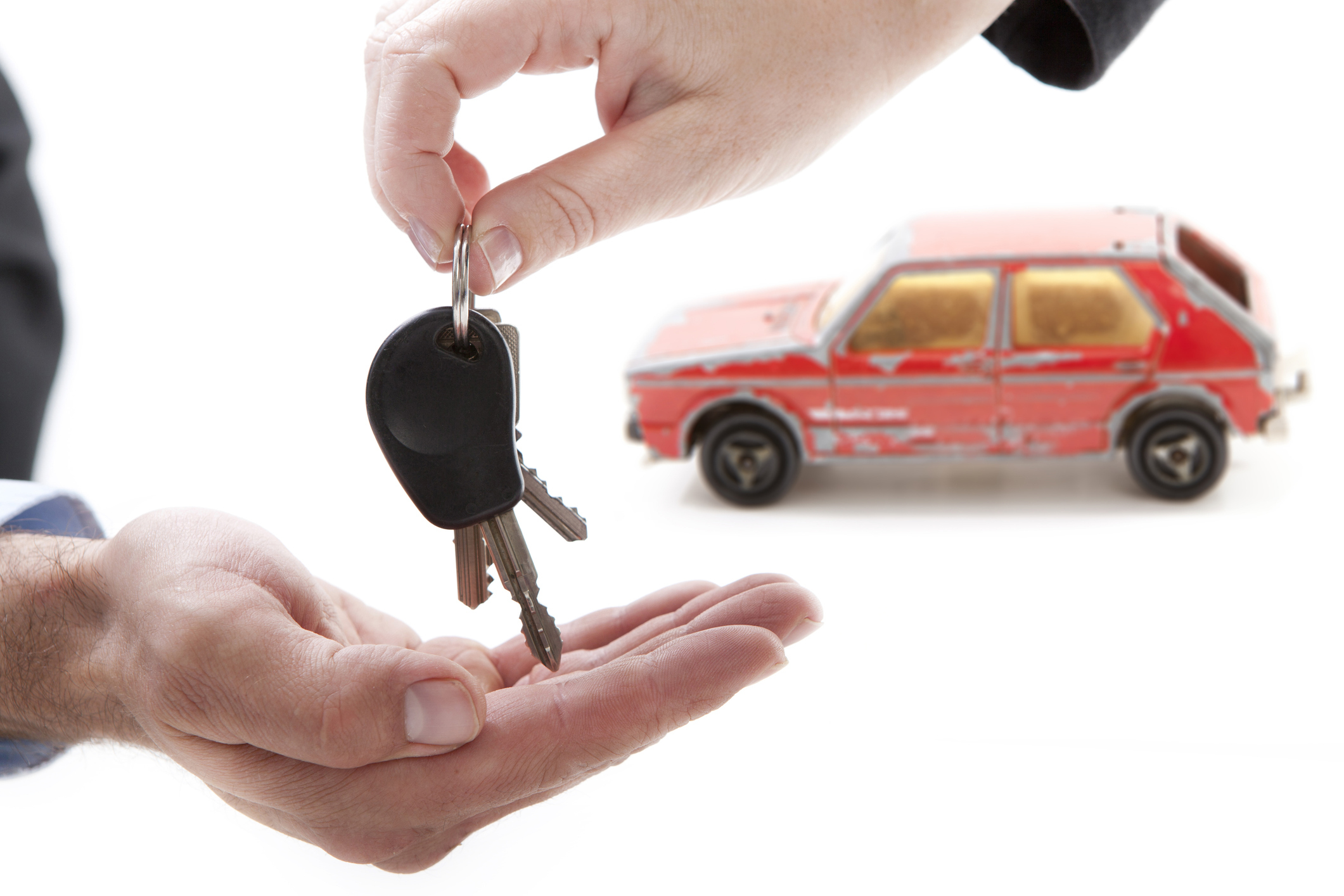 Photo of two hands exchanging car keys
